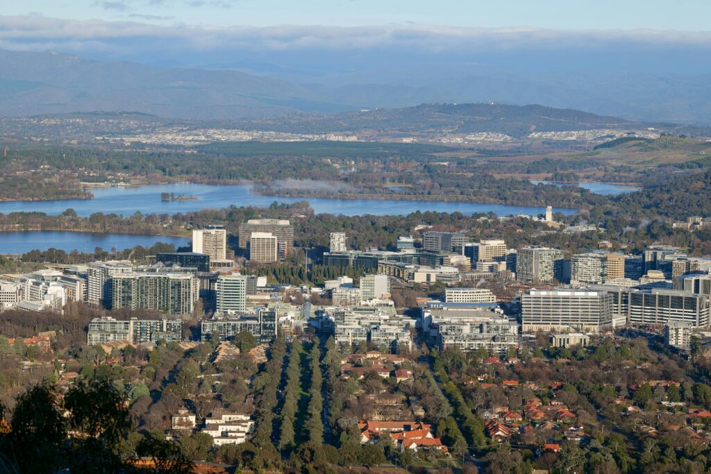 Scenic aerial cityscape of Canberra, Australia's capital, showcasing urban and natural elements.